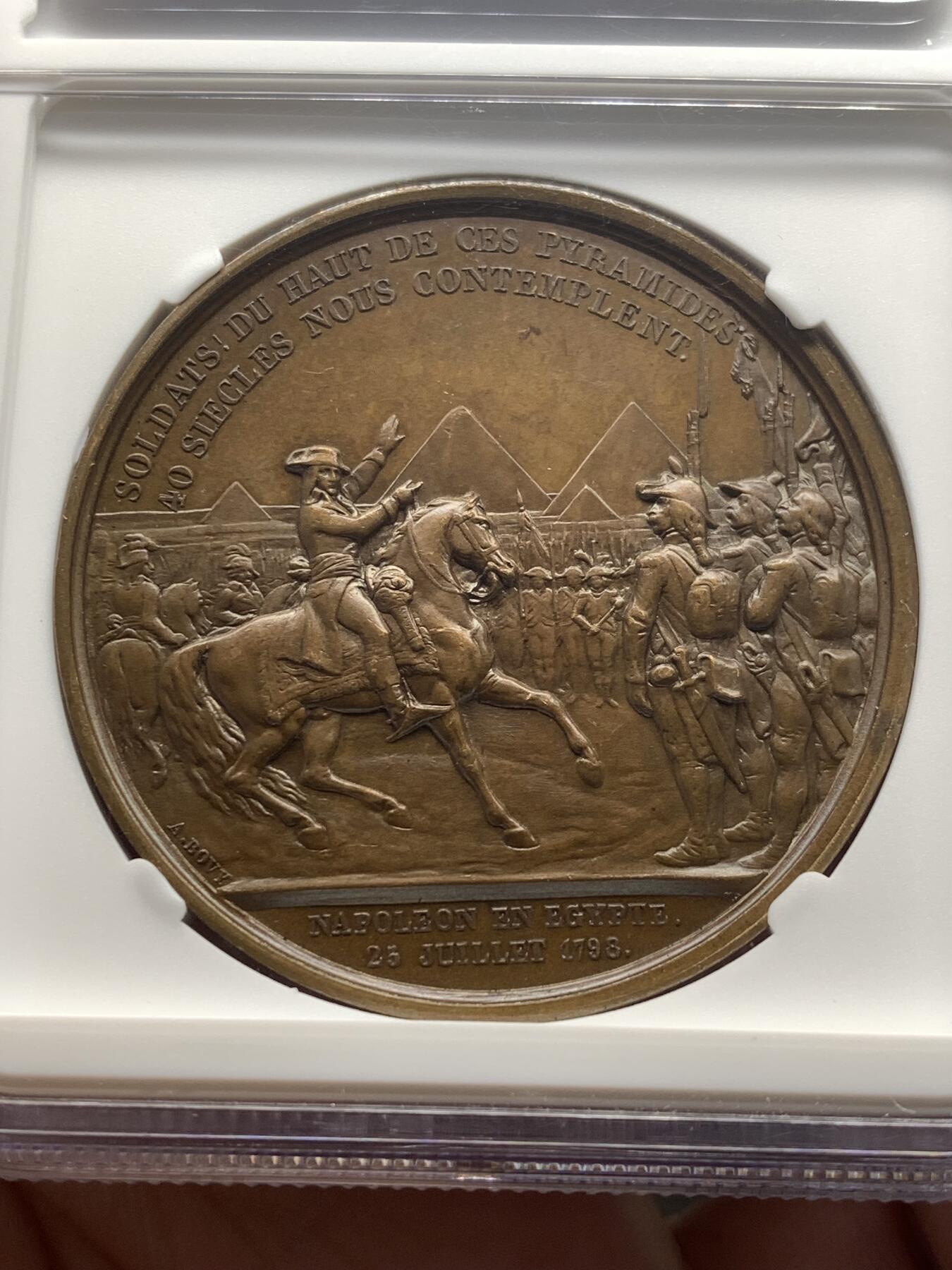 《竞宝斋》第482场 周日，周一 2场连拍 （全场包邮）20级店铺 欢迎送拍 NGC MS64BN 法国拿破仑一世铜章 纪念1798年拿破仑率领法国军队远征埃及 正面为拿破仑·波拿巴右向半身肖像，背面描绘拿破仑骑马在军阵前讲话的场景，远处为埃及金字塔，士兵列队而立，上方铭文“Soldats! du haut de ces pyramides 40 siècles vous contemplent”，意为“士兵们，从这些金字塔的高处，四十个世纪在注视着你们”。加厚盒封装