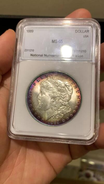 《竞宝斋》第482场 周日，周一 2场连拍 （全场包邮）20级店铺 欢迎送拍 NNC MS65 美国1889年摩根银币 凝夜紫均匀环彩视觉效果极佳 细节见图