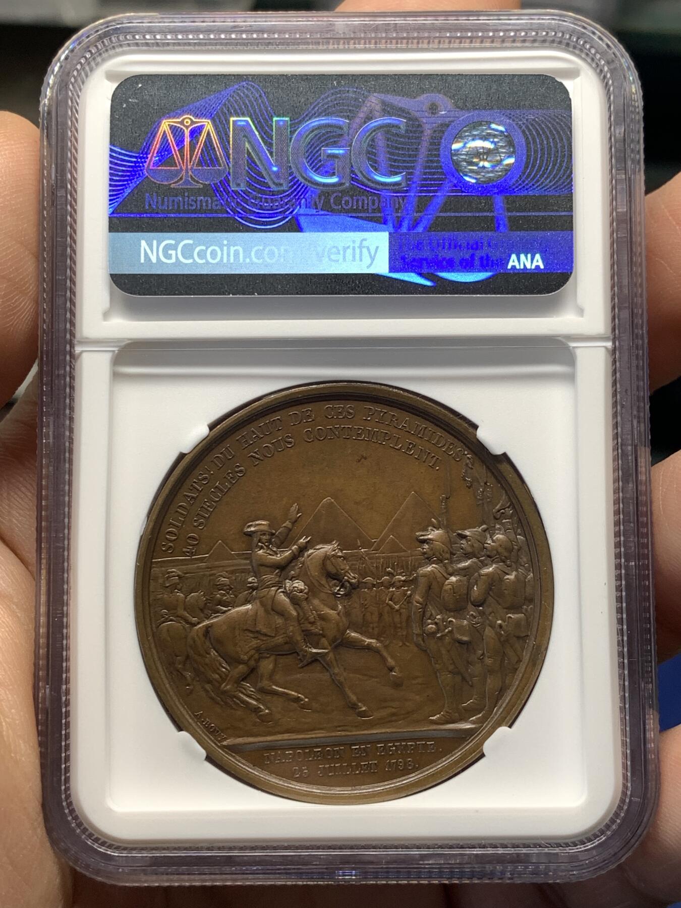 《竞宝斋》第482场 周日，周一 2场连拍 （全场包邮）20级店铺 欢迎送拍 NGC MS64BN 法国拿破仑一世铜章 纪念1798年拿破仑率领法国军队远征埃及 正面为拿破仑·波拿巴右向半身肖像，背面描绘拿破仑骑马在军阵前讲话的场景，远处为埃及金字塔，士兵列队而立，上方铭文“Soldats! du haut de ces pyramides 40 siècles vous contemplent”，意为“士兵们，从这些金字塔的高处，四十个世纪在注视着你们”。加厚盒封装