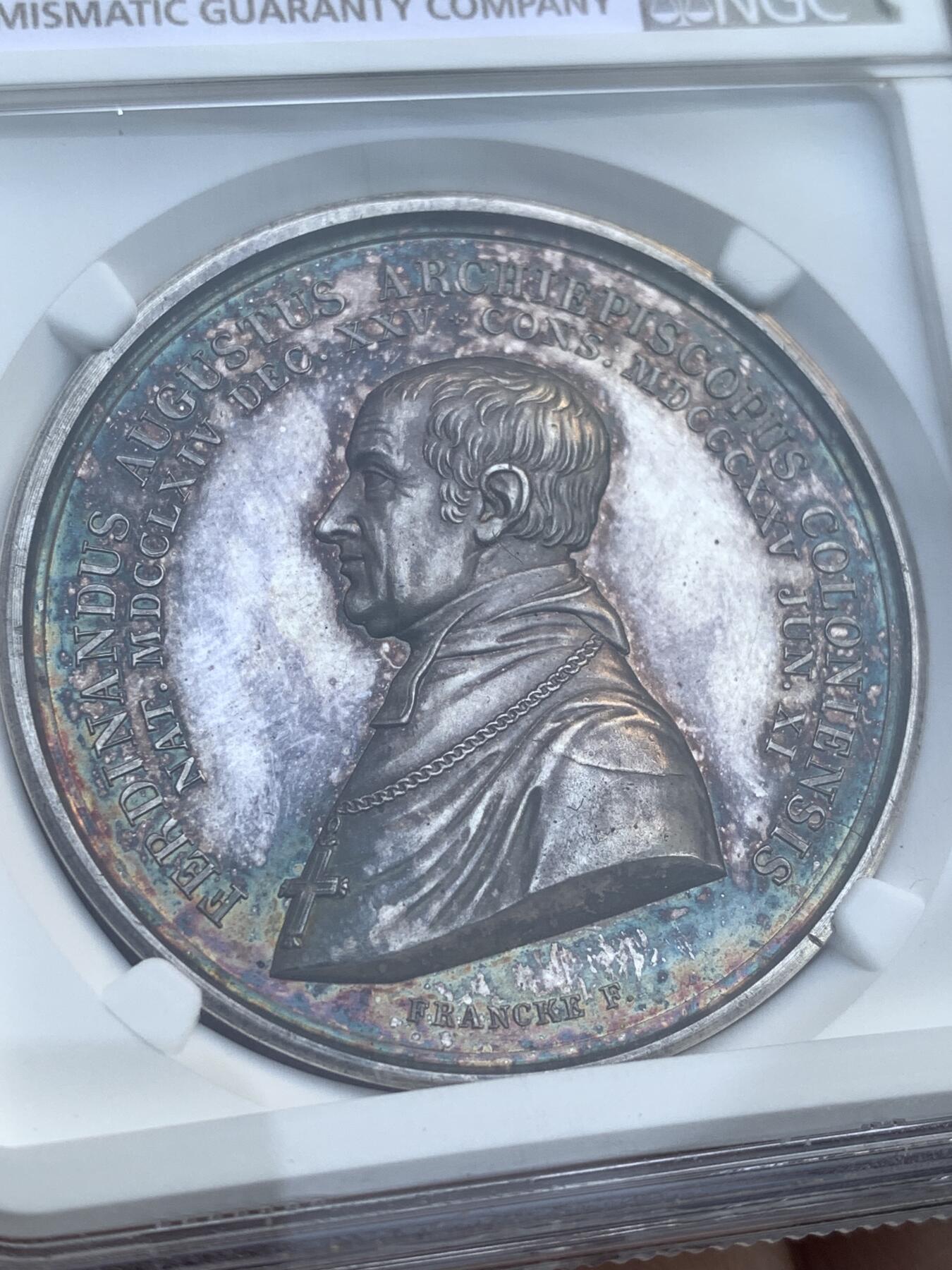 《竞宝斋》第482场 周日，周一 2场连拍 （全场包邮）20级店铺 欢迎送拍 NGC MS63 德国 1833年科隆费迪南德奥古斯塔主教纪念大银章，加厚盒，人物高浮雕，炫五彩包浆，早期德国高艺术性银章，细节雕刻极佳。盒子右侧有损，细节见图。