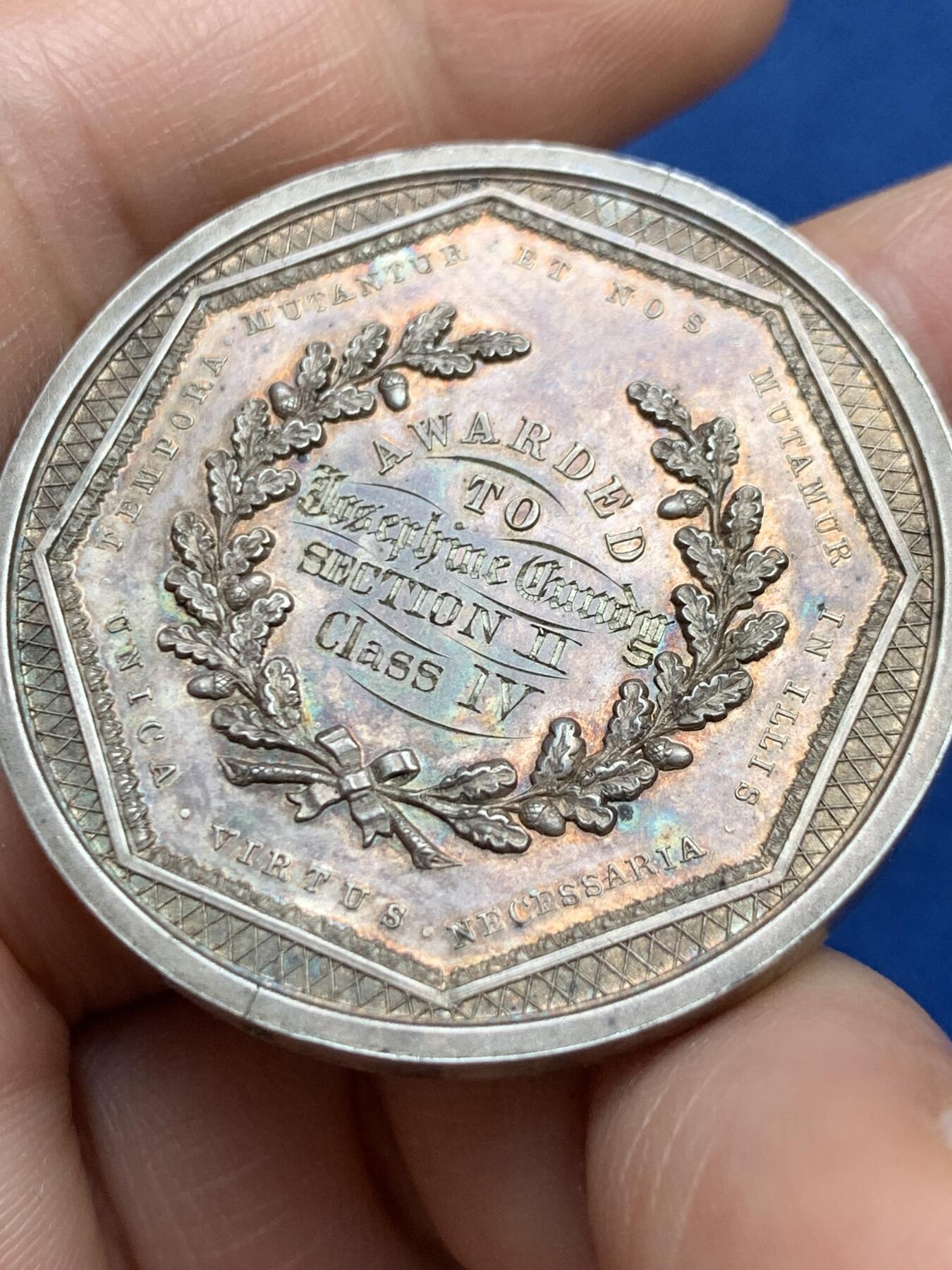 《竞宝斋》第482场 周日，周一 2场连拍 （全场包邮）20级店铺 欢迎送拍 澳大利亚塔斯马尼亚霍巴特市工业展览会银质奖章，罕见的外圆内八造型。边有对孔（挂奖牌）。该章是澳大利亚殖民时期极具代表性的收藏品，极少见，历史价值高。由塔斯马尼亚政府及地方议会主办制造。正面图案：描绘了象征霍巴特的拟人化形象坐于祭坛之上，手持花环。铭文译：以此为基，霍巴特日益强盛。背面 拉丁文箴言译为：时代在变，我们亦随之改变；唯有美德（或技艺）是不可或缺的。直径：38.3m，24.6克。