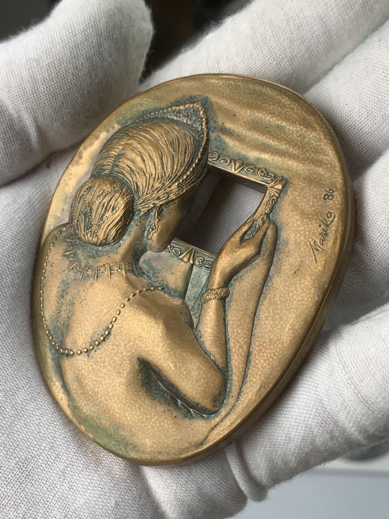 掌中浮雕-藏着的欧洲第059场 1986年美国章币协会#113号章【照镜子的女子】，71 X 58mm，206.5g，原盒带说明，设计雕刻家：Marika Somogyi  ，正面：Woman looking in mirror （照镜子的女子）， 反面：Devil watching through mirror （镜后偷窥的魔鬼），铜章发行量：750枚