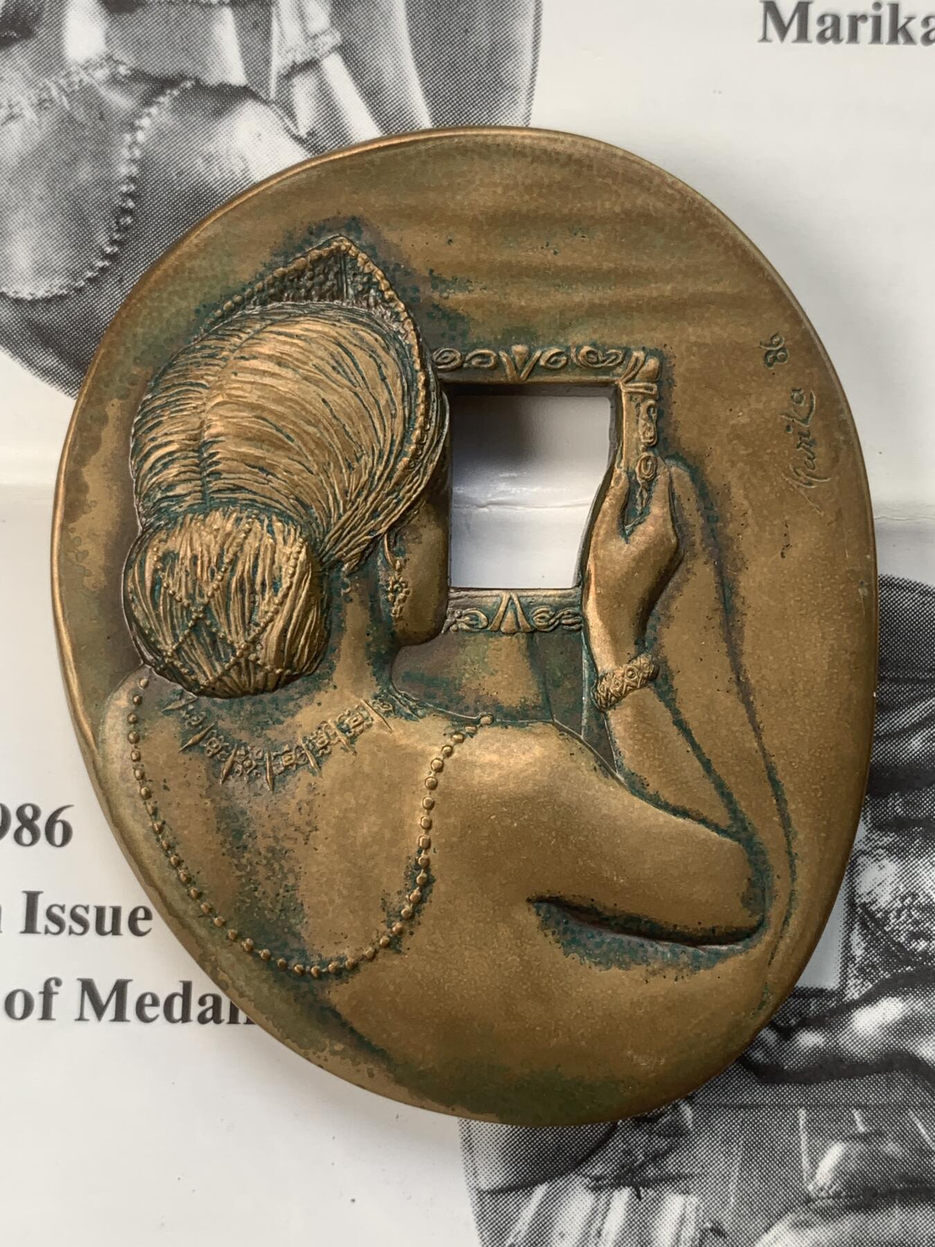 掌中浮雕-藏着的欧洲第059场 1986年美国章币协会#113号章【照镜子的女子】，71 X 58mm，206.5g，原盒带说明，设计雕刻家：Marika Somogyi  ，正面：Woman looking in mirror （照镜子的女子）， 反面：Devil watching through mirror （镜后偷窥的魔鬼），铜章发行量：750枚