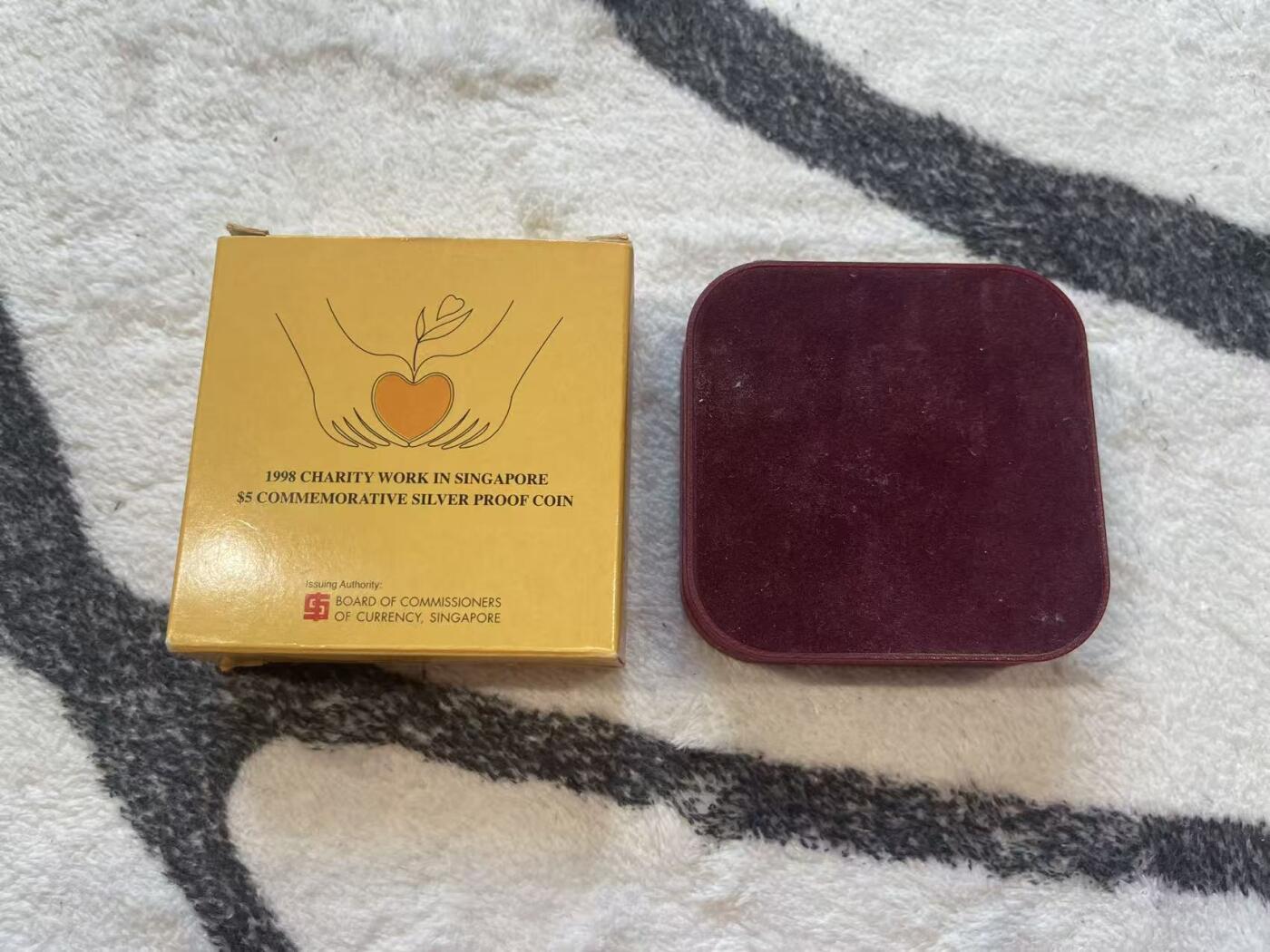 ❤️【币观天下】❤️ 第349期钱币拍卖场- 2026.4.24周五晚上6点半场 长期征集拍品  新加坡1998年爱心慈善精制纪念银币 含0.3克镶嵌金 20克银+0.3克金 盒证全齐 