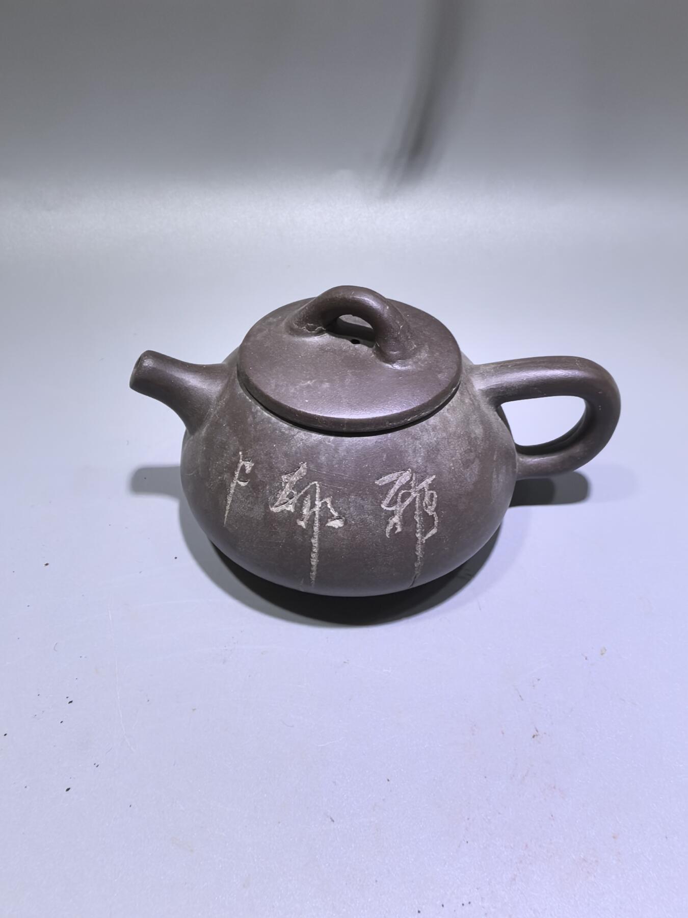 旧藏紫泥石瓢壶，原矿紫泥胎质，包浆温润古旧。壶身阴刻草书，刀笔劲挺，添几分文人气韵。石瓢形制经典，器型稳正，是兼具实用与赏玩的老茶器。