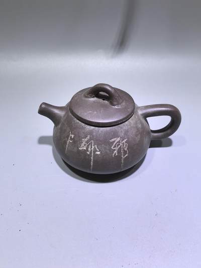 旧藏紫泥石瓢壶，原矿紫泥胎质，包浆温润古旧。壶身阴刻草书，刀笔劲挺，添几分文人气韵。石瓢形制经典，器型稳正，是兼具实用与赏玩的老茶器。 - 旧藏紫泥石瓢壶，原矿紫泥胎质，包浆温润古旧。壶身阴刻草书，刀笔劲挺，添几分文人气韵。石瓢形制经典，器型稳正，是兼具实用与赏玩的老茶器。