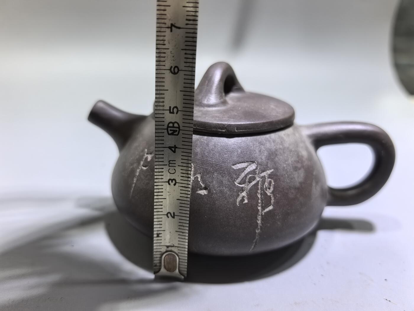 旧藏紫泥石瓢壶，原矿紫泥胎质，包浆温润古旧。壶身阴刻草书，刀笔劲挺，添几分文人气韵。石瓢形制经典，器型稳正，是兼具实用与赏玩的老茶器。