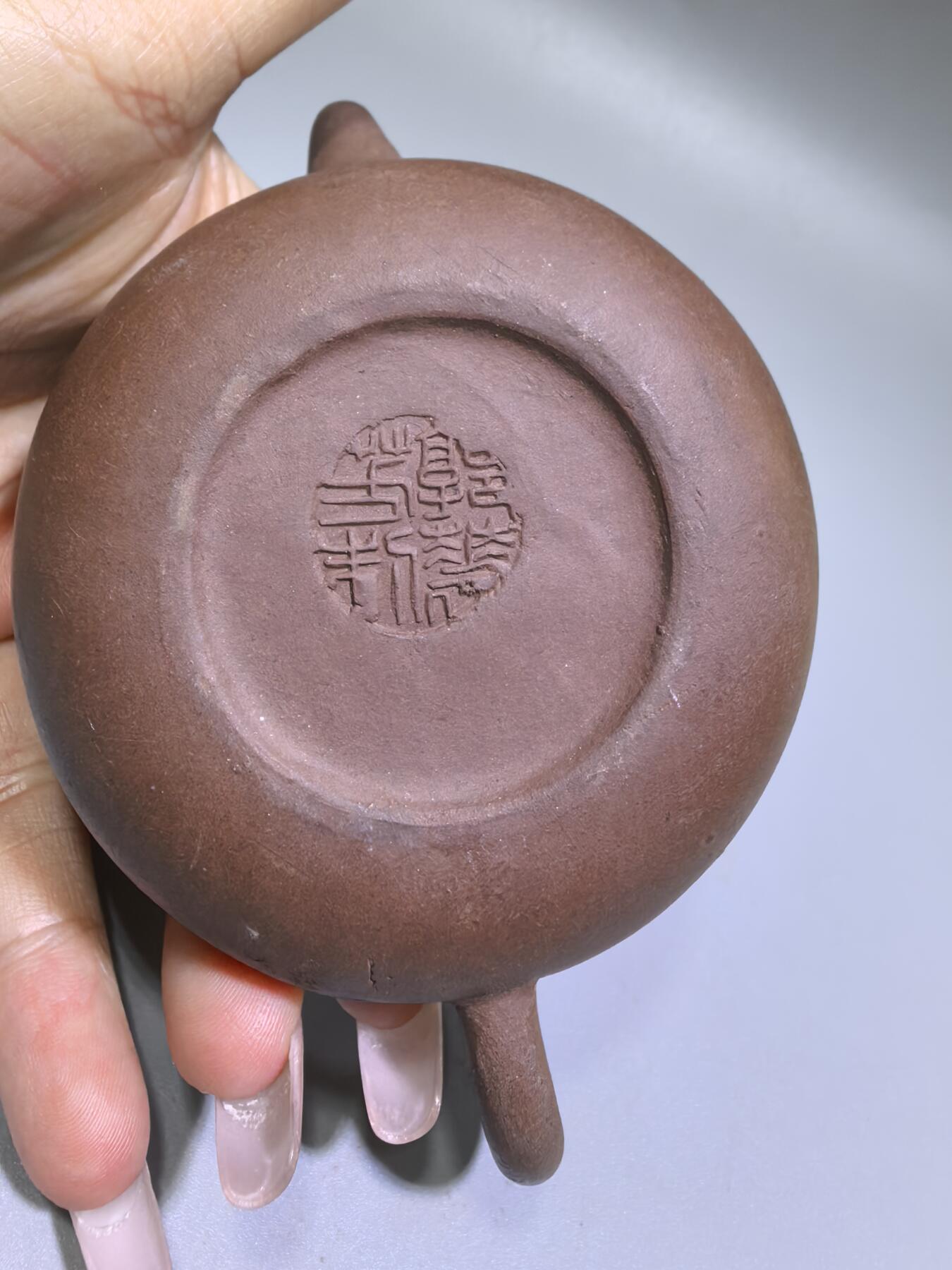 旧藏紫砂老壶，取原矿紫泥为料，泥色温润沉穆，包浆由岁月与茶汤浸润而成，光气内敛，尽显旧物之美。壶型饱满敦实，盖钮圆润如珠，壶流短直流畅，壶把圈握趁手，整体线条简练流畅，颇具传统工夫茶器的朴雅气质。高约6.0cm长约10.5cm