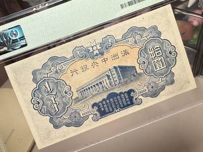 （自动截拍）PMG评级民国纸币专拍第20260424期，全场包邮 【乾奕收藏】出民国33年1944年满洲中央银行财神像圆，财神赵公明图案，丙券长号码版本，美国PMG64分