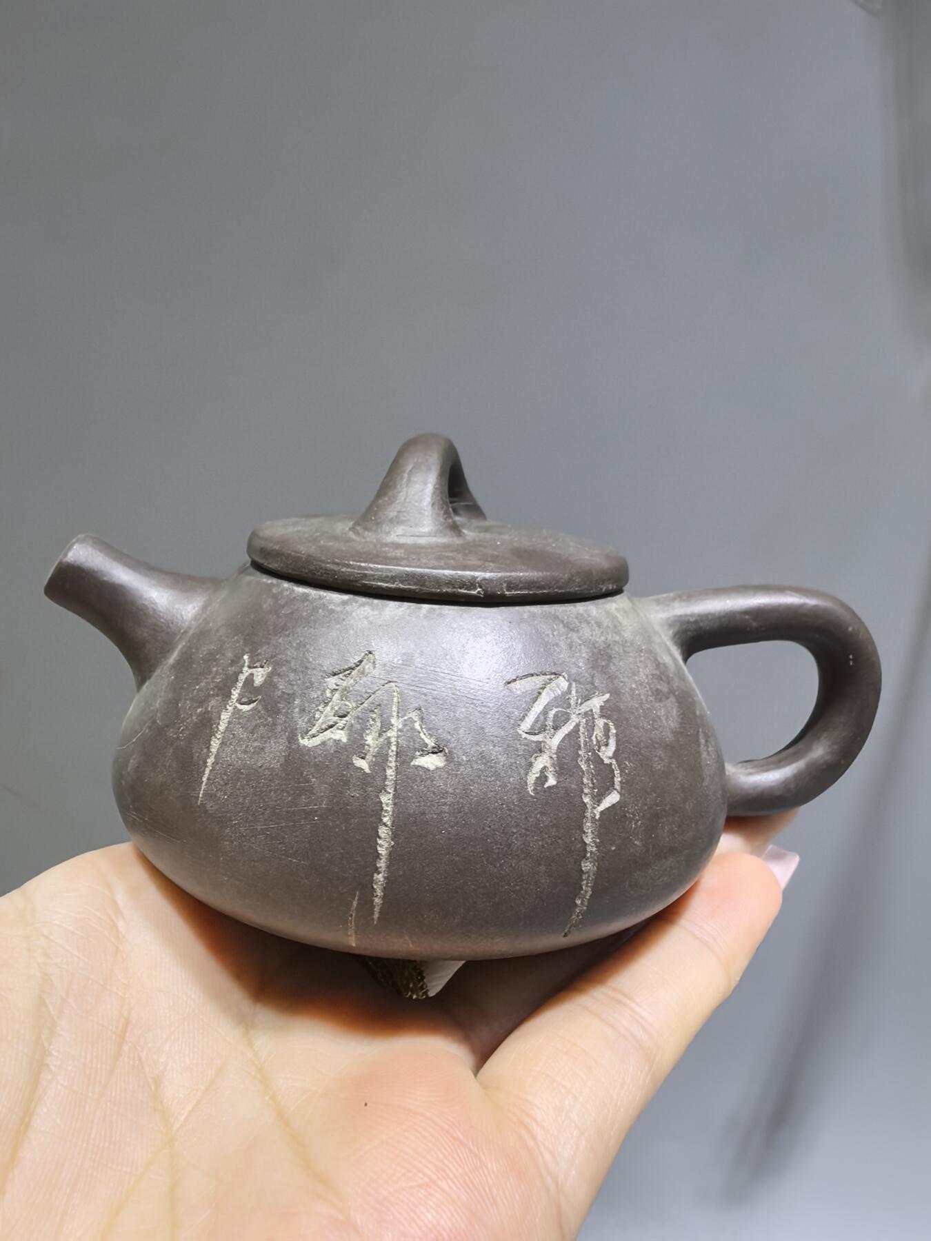 旧藏紫泥石瓢壶，原矿紫泥胎质，包浆温润古旧。壶身阴刻草书，刀笔劲挺，添几分文人气韵。石瓢形制经典，器型稳正，是兼具实用与赏玩的老茶器。