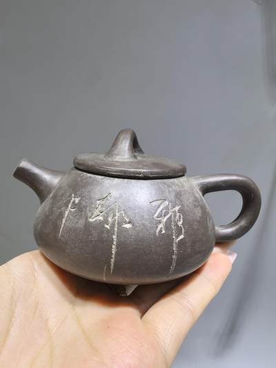 旧藏紫泥石瓢壶，原矿紫泥胎质，包浆温润古旧。壶身阴刻草书，刀笔劲挺，添几分文人气韵。石瓢形制经典，器型稳正，是兼具实用与赏玩的老茶器。 旧藏紫泥石瓢壶，原矿紫泥胎质，包浆温润古旧。壶身阴刻草书，刀笔劲挺，添几分文人气韵。石瓢形制经典，器型稳正，是兼具实用与赏玩的老茶器。
