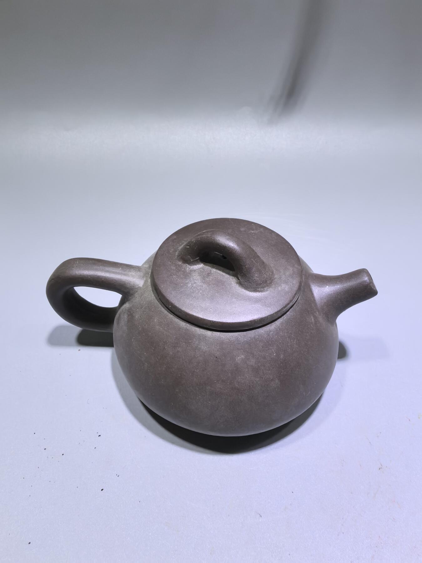 旧藏紫泥石瓢壶，原矿紫泥胎质，包浆温润古旧。壶身阴刻草书，刀笔劲挺，添几分文人气韵。石瓢形制经典，器型稳正，是兼具实用与赏玩的老茶器。