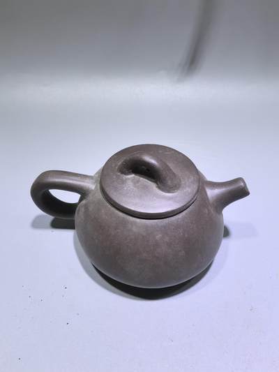 旧藏紫泥石瓢壶，原矿紫泥胎质，包浆温润古旧。壶身阴刻草书，刀笔劲挺，添几分文人气韵。石瓢形制经典，器型稳正，是兼具实用与赏玩的老茶器。 旧藏紫泥石瓢壶，原矿紫泥胎质，包浆温润古旧。壶身阴刻草书，刀笔劲挺，添几分文人气韵。石瓢形制经典，器型稳正，是兼具实用与赏玩的老茶器。