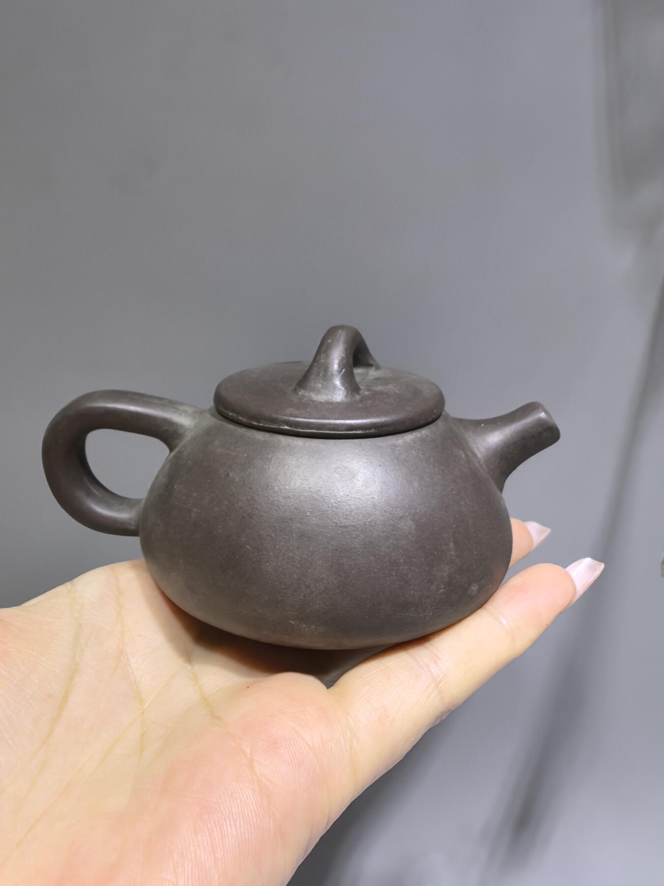 旧藏紫泥石瓢壶，原矿紫泥胎质，包浆温润古旧。壶身阴刻草书，刀笔劲挺，添几分文人气韵。石瓢形制经典，器型稳正，是兼具实用与赏玩的老茶器。