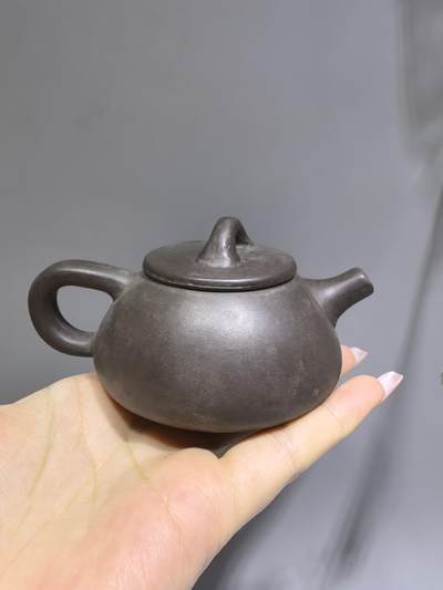 旧藏紫泥石瓢壶，原矿紫泥胎质，包浆温润古旧。壶身阴刻草书，刀笔劲挺，添几分文人气韵。石瓢形制经典，器型稳正，是兼具实用与赏玩的老茶器。 旧藏紫泥石瓢壶，原矿紫泥胎质，包浆温润古旧。壶身阴刻草书，刀笔劲挺，添几分文人气韵。石瓢形制经典，器型稳正，是兼具实用与赏玩的老茶器。