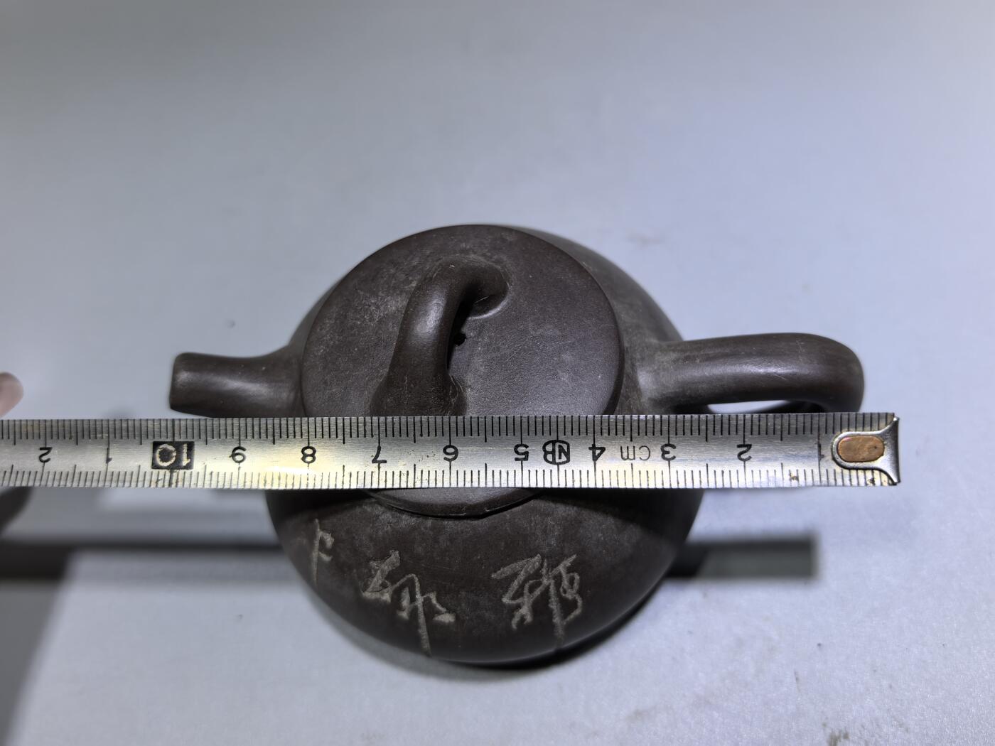 旧藏紫泥石瓢壶，原矿紫泥胎质，包浆温润古旧。壶身阴刻草书，刀笔劲挺，添几分文人气韵。石瓢形制经典，器型稳正，是兼具实用与赏玩的老茶器。