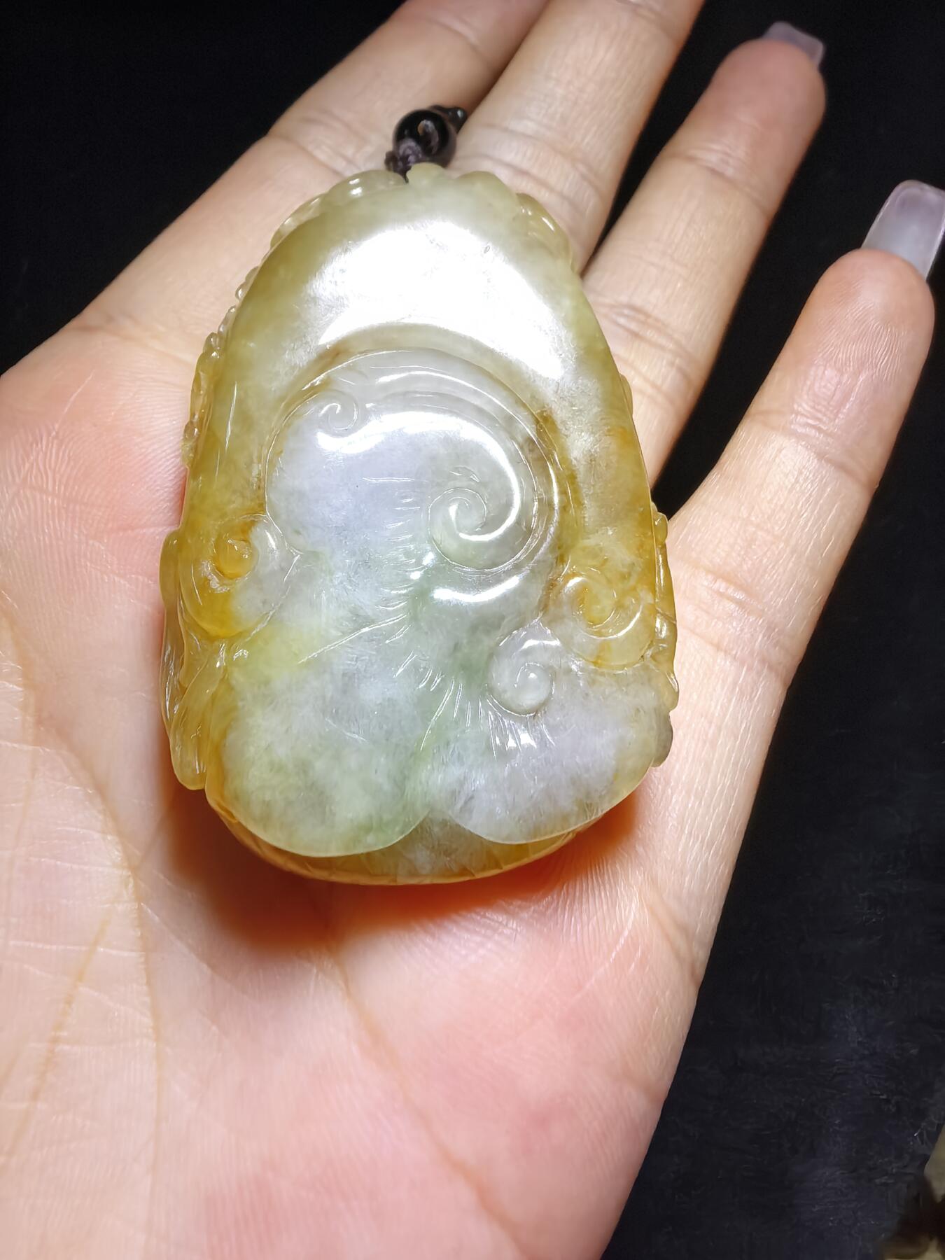 精选天然黄翡龙牌，色泽温润如蜜，通透莹亮。整料随形巧雕，龙纹苍劲灵动，盘曲间尽展威严；背面如意纹饰，线条流畅，寓意顺遂安康。黄翡为“金”，龙主祥瑞，金运与贵气相融，是随身护佑的雅器，亦是收藏赏玩的佳选。5.2cm*3.5cm*1.3cm