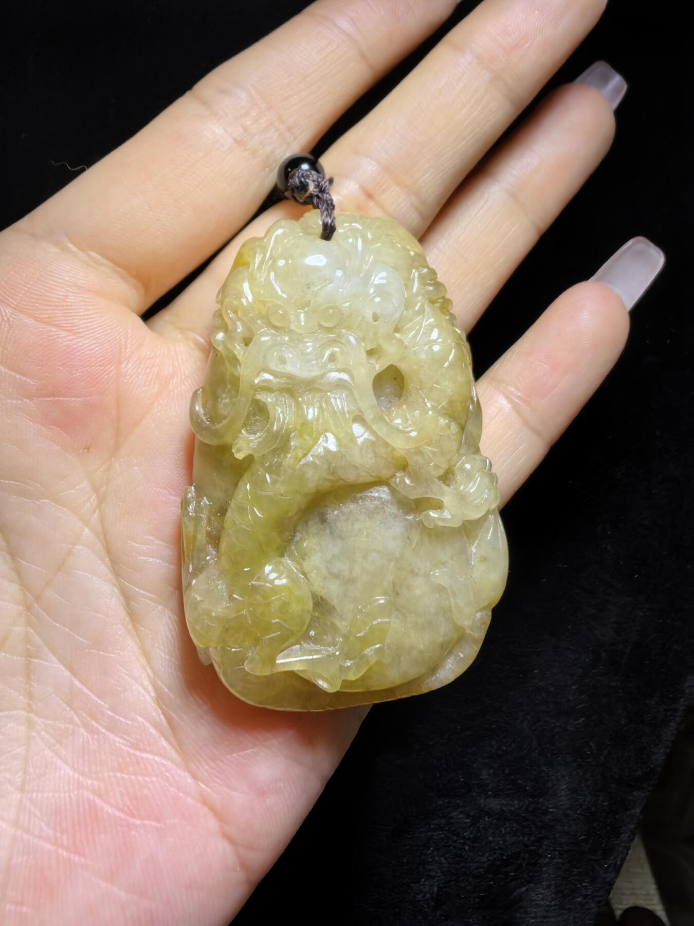 精选天然黄翡龙牌，色泽温润如蜜，通透莹亮。整料随形巧雕，龙纹苍劲灵动，盘曲间尽展威严；背面如意纹饰，线条流畅，寓意顺遂安康。黄翡为“金”，龙主祥瑞，金运与贵气相融，是随身护佑的雅器，亦是收藏赏玩的佳选。5.2cm*3.5cm*1.3cm