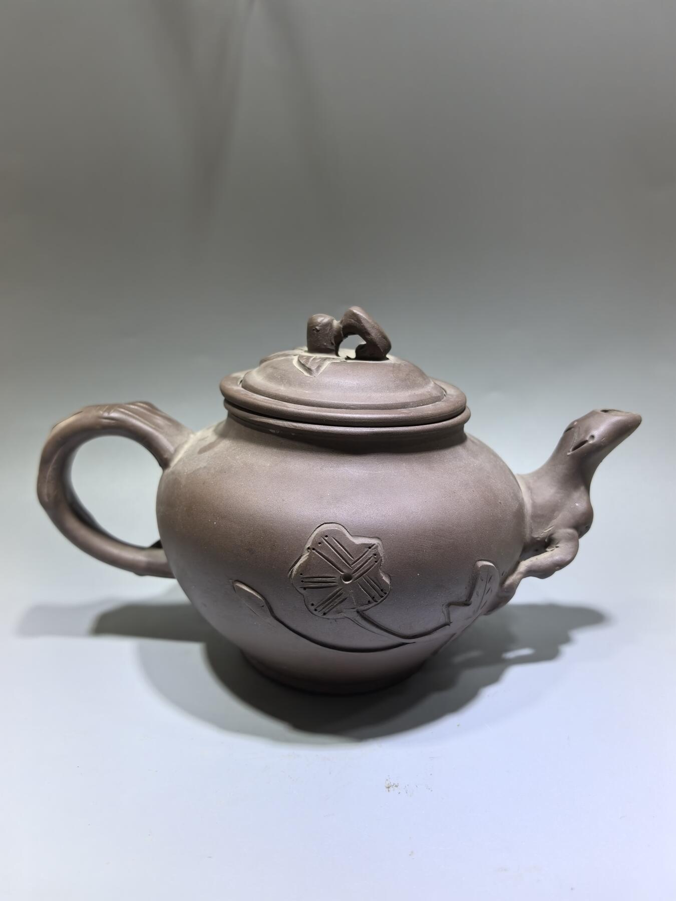 旧藏老紫泥梅桩紫砂壶，精选原矿紫泥，质地温润细腻，自带岁月沉淀的包浆质感。壶身以梅桩为形，壶嘴、壶把、盖钮皆塑为梅枝，壶身贴塑梅花纹饰，线条简练生动，尽显梅的傲骨清韵。器型饱满周正，出水流畅，是兼具实用与收藏价值的文玩茶器。