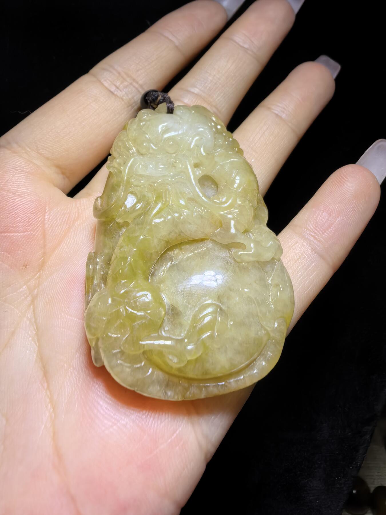 精选天然黄翡龙牌，色泽温润如蜜，通透莹亮。整料随形巧雕，龙纹苍劲灵动，盘曲间尽展威严；背面如意纹饰，线条流畅，寓意顺遂安康。黄翡为“金”，龙主祥瑞，金运与贵气相融，是随身护佑的雅器，亦是收藏赏玩的佳选。5.2cm*3.5cm*1.3cm