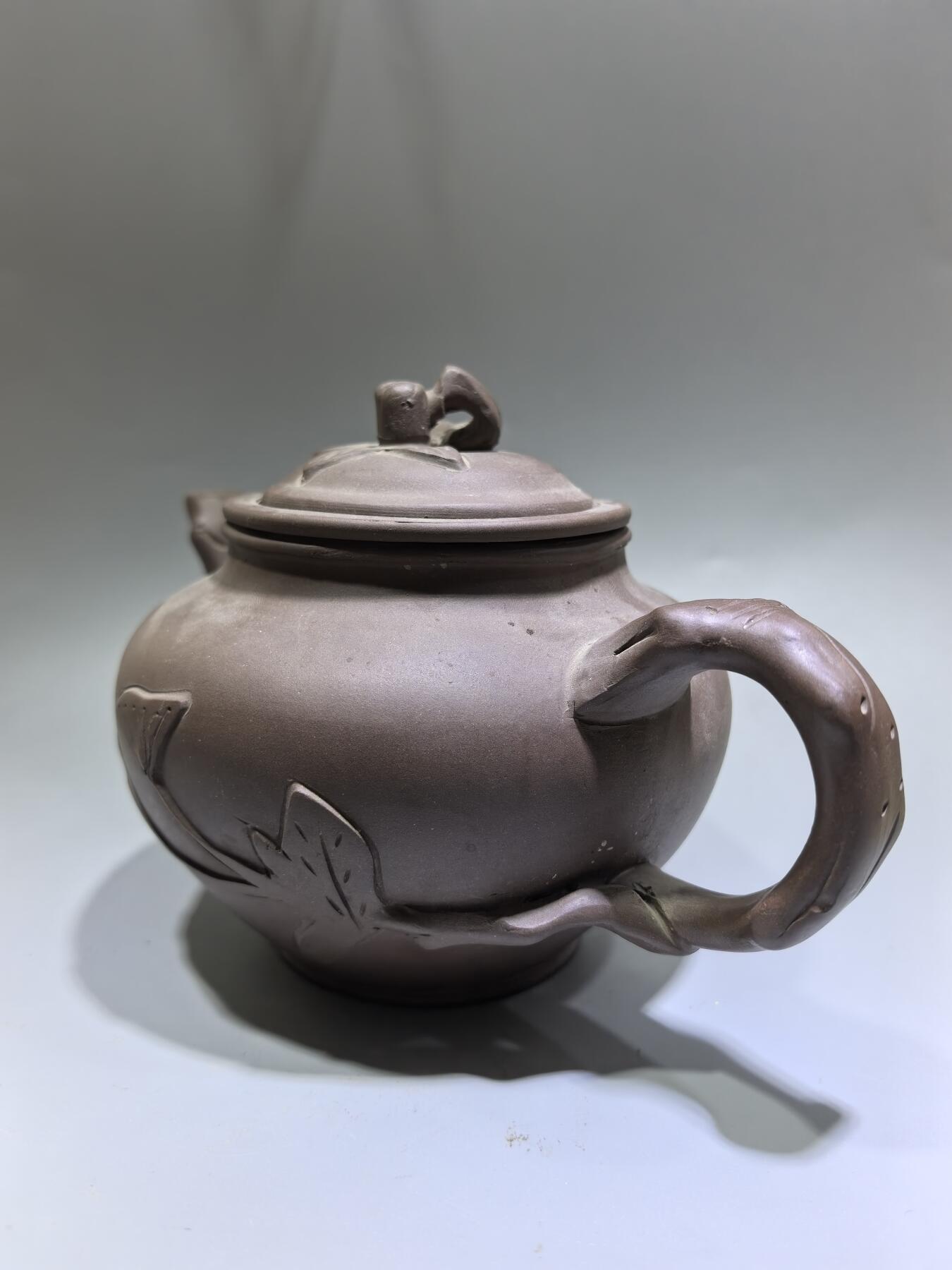 旧藏老紫泥梅桩紫砂壶，精选原矿紫泥，质地温润细腻，自带岁月沉淀的包浆质感。壶身以梅桩为形，壶嘴、壶把、盖钮皆塑为梅枝，壶身贴塑梅花纹饰，线条简练生动，尽显梅的傲骨清韵。器型饱满周正，出水流畅，是兼具实用与收藏价值的文玩茶器。