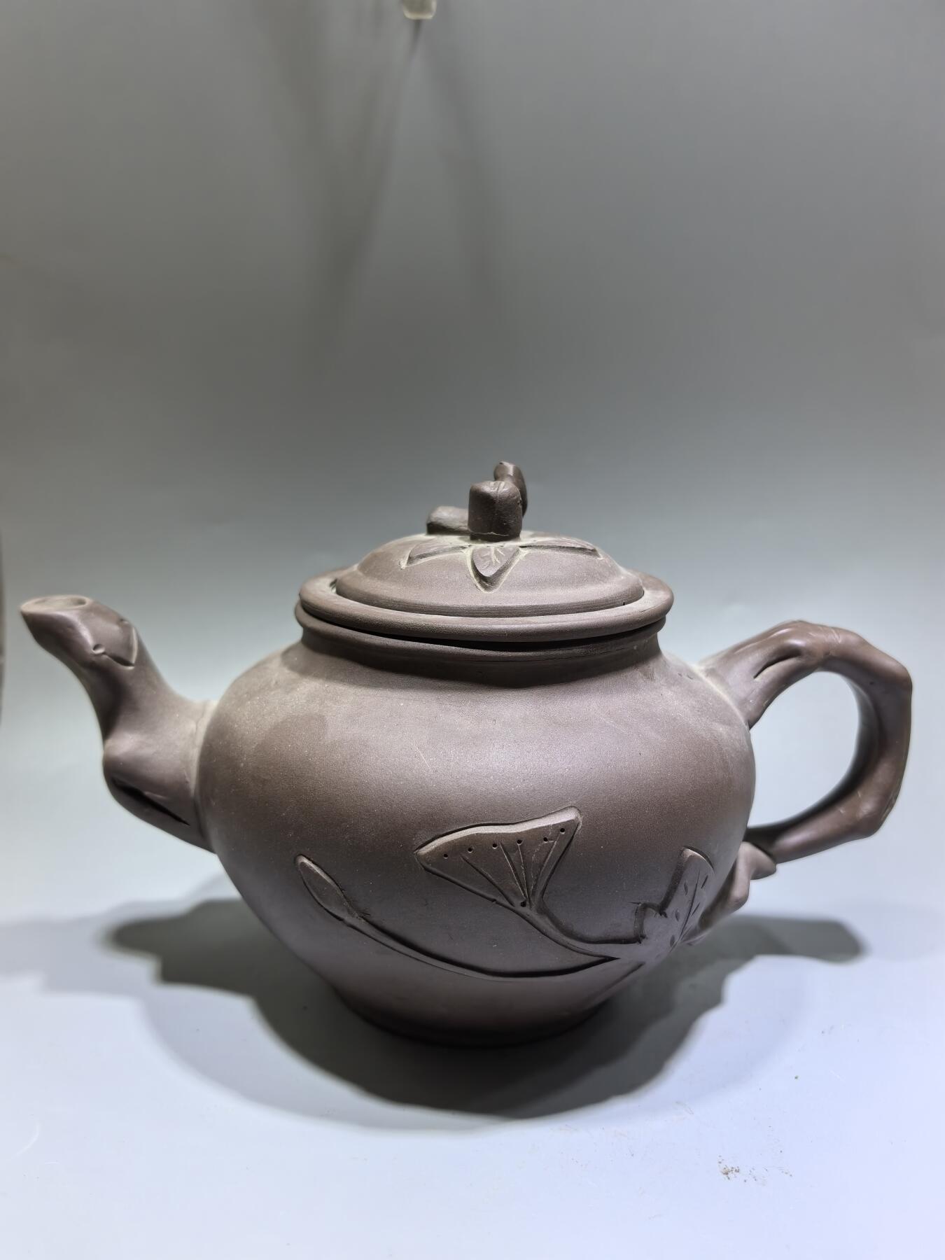 旧藏老紫泥梅桩紫砂壶，精选原矿紫泥，质地温润细腻，自带岁月沉淀的包浆质感。壶身以梅桩为形，壶嘴、壶把、盖钮皆塑为梅枝，壶身贴塑梅花纹饰，线条简练生动，尽显梅的傲骨清韵。器型饱满周正，出水流畅，是兼具实用与收藏价值的文玩茶器。