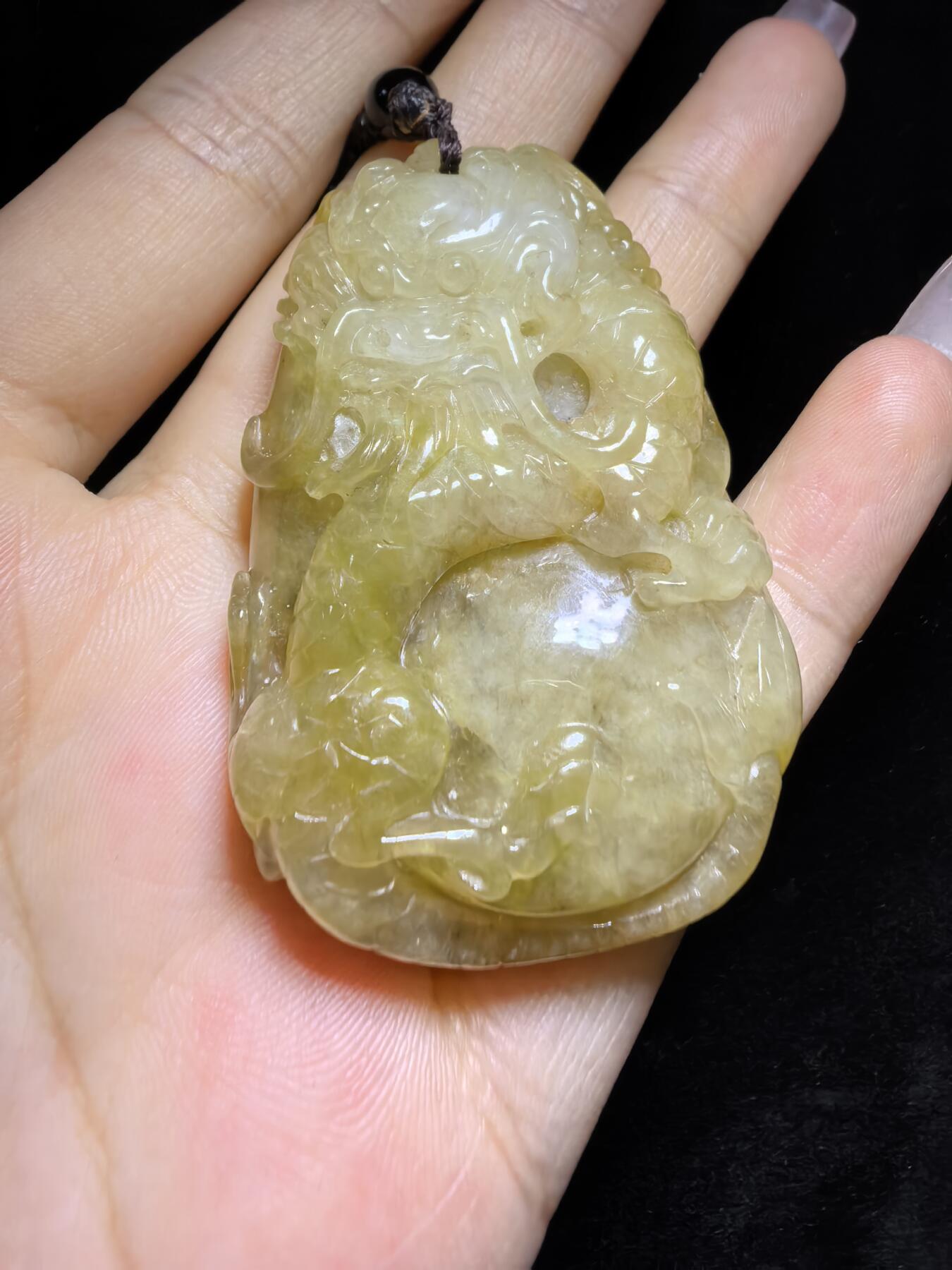 精选天然黄翡龙牌，色泽温润如蜜，通透莹亮。整料随形巧雕，龙纹苍劲灵动，盘曲间尽展威严；背面如意纹饰，线条流畅，寓意顺遂安康。黄翡为“金”，龙主祥瑞，金运与贵气相融，是随身护佑的雅器，亦是收藏赏玩的佳选。5.2cm*3.5cm*1.3cm