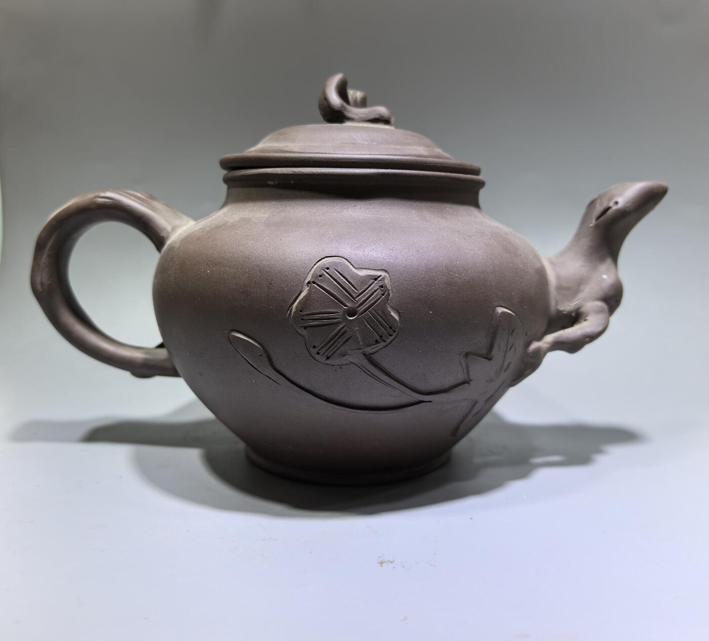 旧藏老紫泥梅桩紫砂壶，精选原矿紫泥，质地温润细腻，自带岁月沉淀的包浆质感。壶身以梅桩为形，壶嘴、壶把、盖钮皆塑为梅枝，壶身贴塑梅花纹饰，线条简练生动，尽显梅的傲骨清韵。器型饱满周正，出水流畅，是兼具实用与收藏价值的文玩茶器。