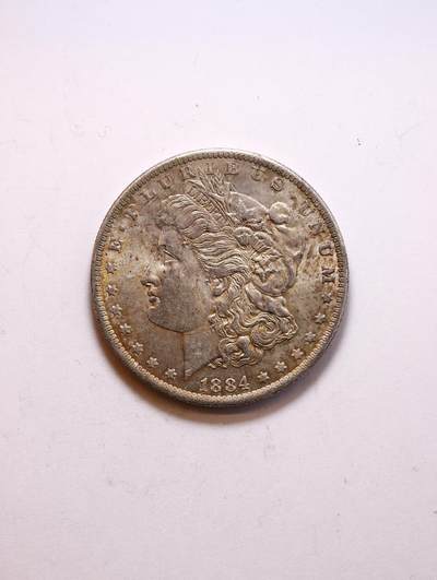 观钱 近现代机制币拍卖No.010（全场顺丰包邮，不区分偏远地区，本场5月5日开始发货）  - 美国  1884 摩根一元（新奥尔良厂）  未流通品相 转光丝绒  黄油包浆天然包浆，无严重流通磨损痕迹，摩根女神的发丝、花冠细节清晰，背面老鹰图案完整锐利，底板状态良好