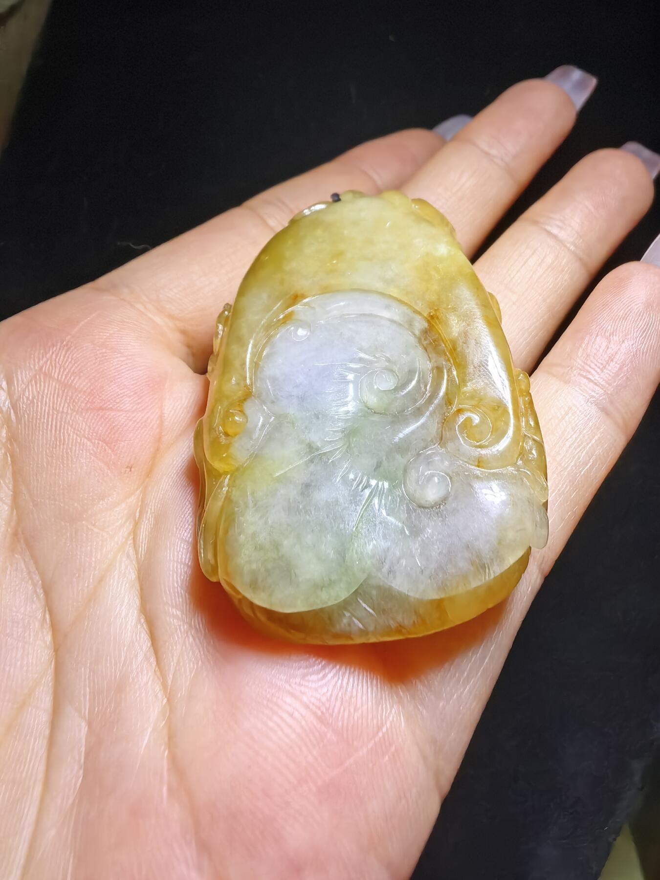 精选天然黄翡龙牌，色泽温润如蜜，通透莹亮。整料随形巧雕，龙纹苍劲灵动，盘曲间尽展威严；背面如意纹饰，线条流畅，寓意顺遂安康。黄翡为“金”，龙主祥瑞，金运与贵气相融，是随身护佑的雅器，亦是收藏赏玩的佳选。5.2cm*3.5cm*1.3cm