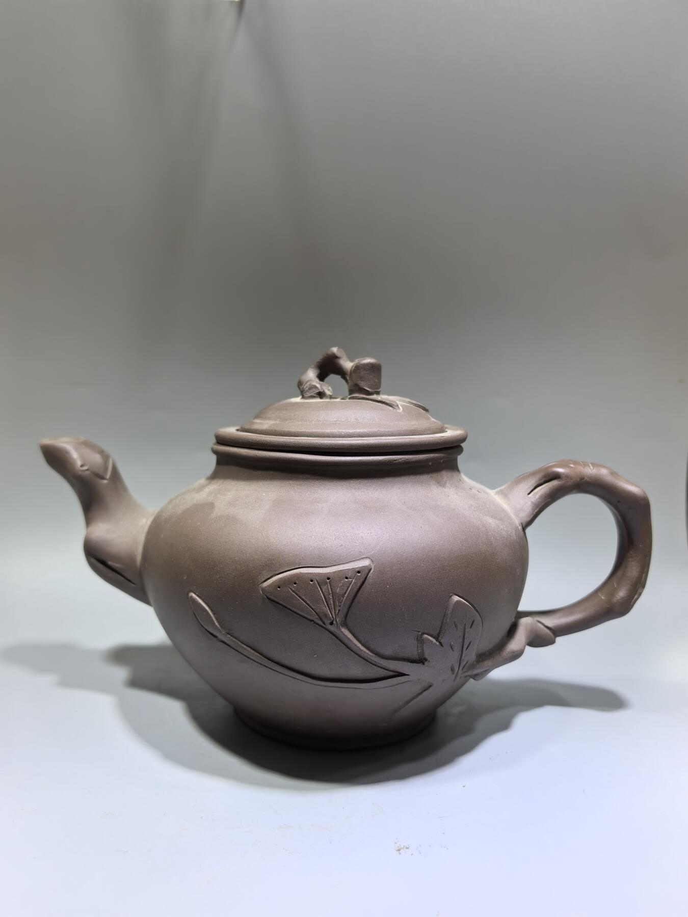 旧藏老紫泥梅桩紫砂壶，精选原矿紫泥，质地温润细腻，自带岁月沉淀的包浆质感。壶身以梅桩为形，壶嘴、壶把、盖钮皆塑为梅枝，壶身贴塑梅花纹饰，线条简练生动，尽显梅的傲骨清韵。器型饱满周正，出水流畅，是兼具实用与收藏价值的文玩茶器。