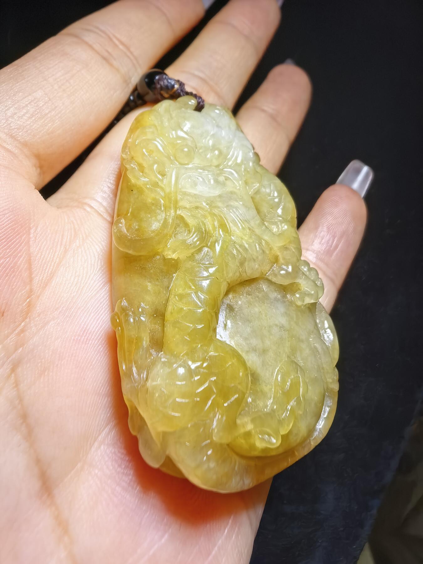 精选天然黄翡龙牌，色泽温润如蜜，通透莹亮。整料随形巧雕，龙纹苍劲灵动，盘曲间尽展威严；背面如意纹饰，线条流畅，寓意顺遂安康。黄翡为“金”，龙主祥瑞，金运与贵气相融，是随身护佑的雅器，亦是收藏赏玩的佳选。5.2cm*3.5cm*1.3cm