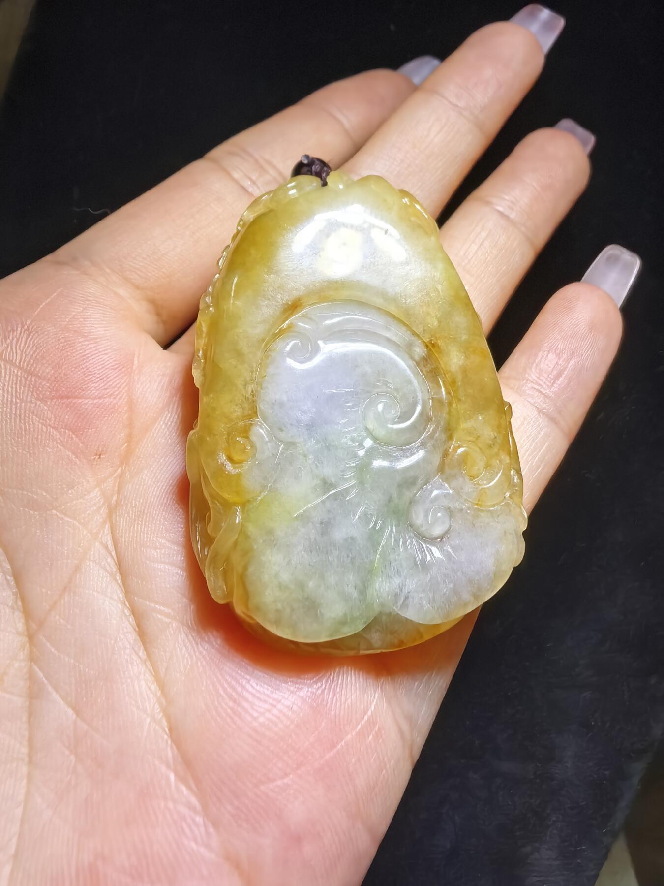 精选天然黄翡龙牌，色泽温润如蜜，通透莹亮。整料随形巧雕，龙纹苍劲灵动，盘曲间尽展威严；背面如意纹饰，线条流畅，寓意顺遂安康。黄翡为“金”，龙主祥瑞，金运与贵气相融，是随身护佑的雅器，亦是收藏赏玩的佳选。5.2cm*3.5cm*1.3cm