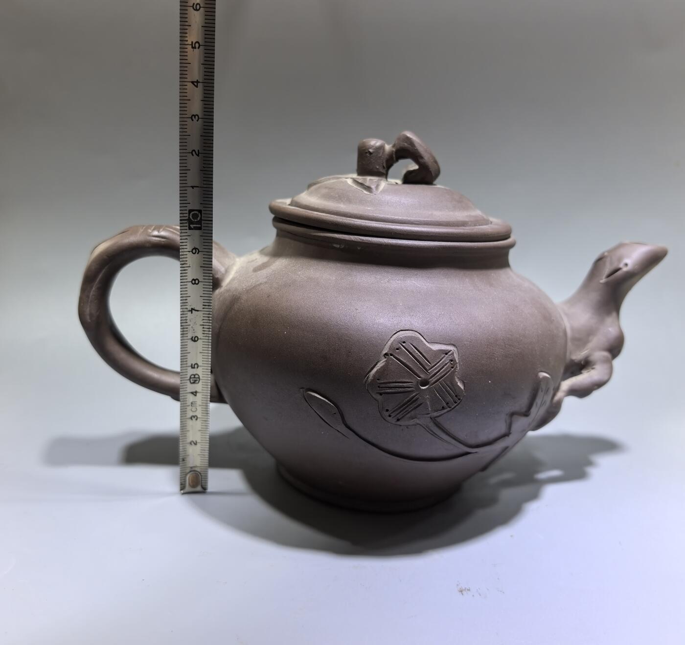 旧藏老紫泥梅桩紫砂壶，精选原矿紫泥，质地温润细腻，自带岁月沉淀的包浆质感。壶身以梅桩为形，壶嘴、壶把、盖钮皆塑为梅枝，壶身贴塑梅花纹饰，线条简练生动，尽显梅的傲骨清韵。器型饱满周正，出水流畅，是兼具实用与收藏价值的文玩茶器。