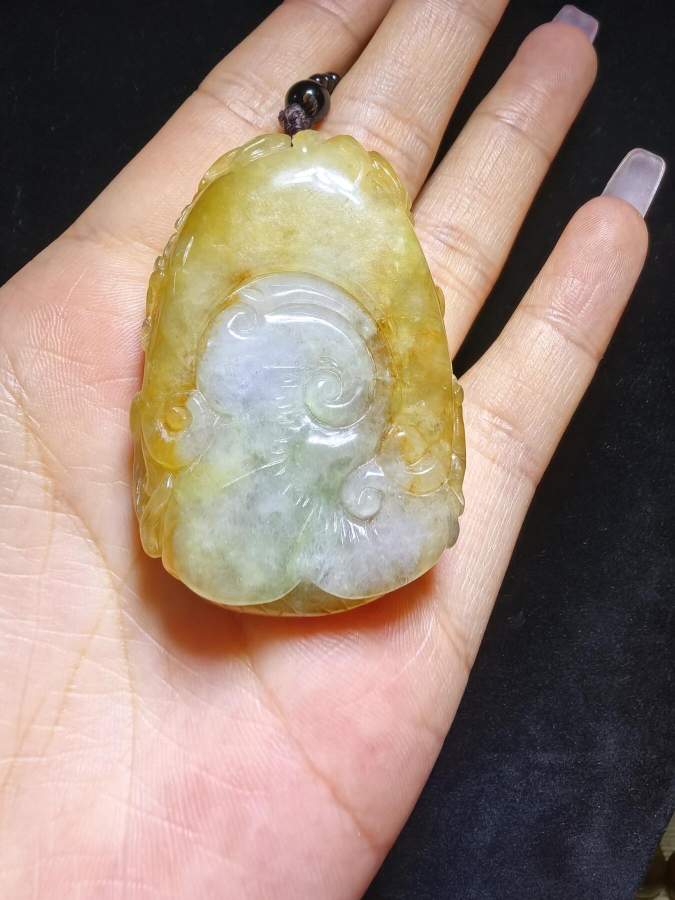 精选天然黄翡龙牌，色泽温润如蜜，通透莹亮。整料随形巧雕，龙纹苍劲灵动，盘曲间尽展威严；背面如意纹饰，线条流畅，寓意顺遂安康。黄翡为“金”，龙主祥瑞，金运与贵气相融，是随身护佑的雅器，亦是收藏赏玩的佳选。5.2cm*3.5cm*1.3cm