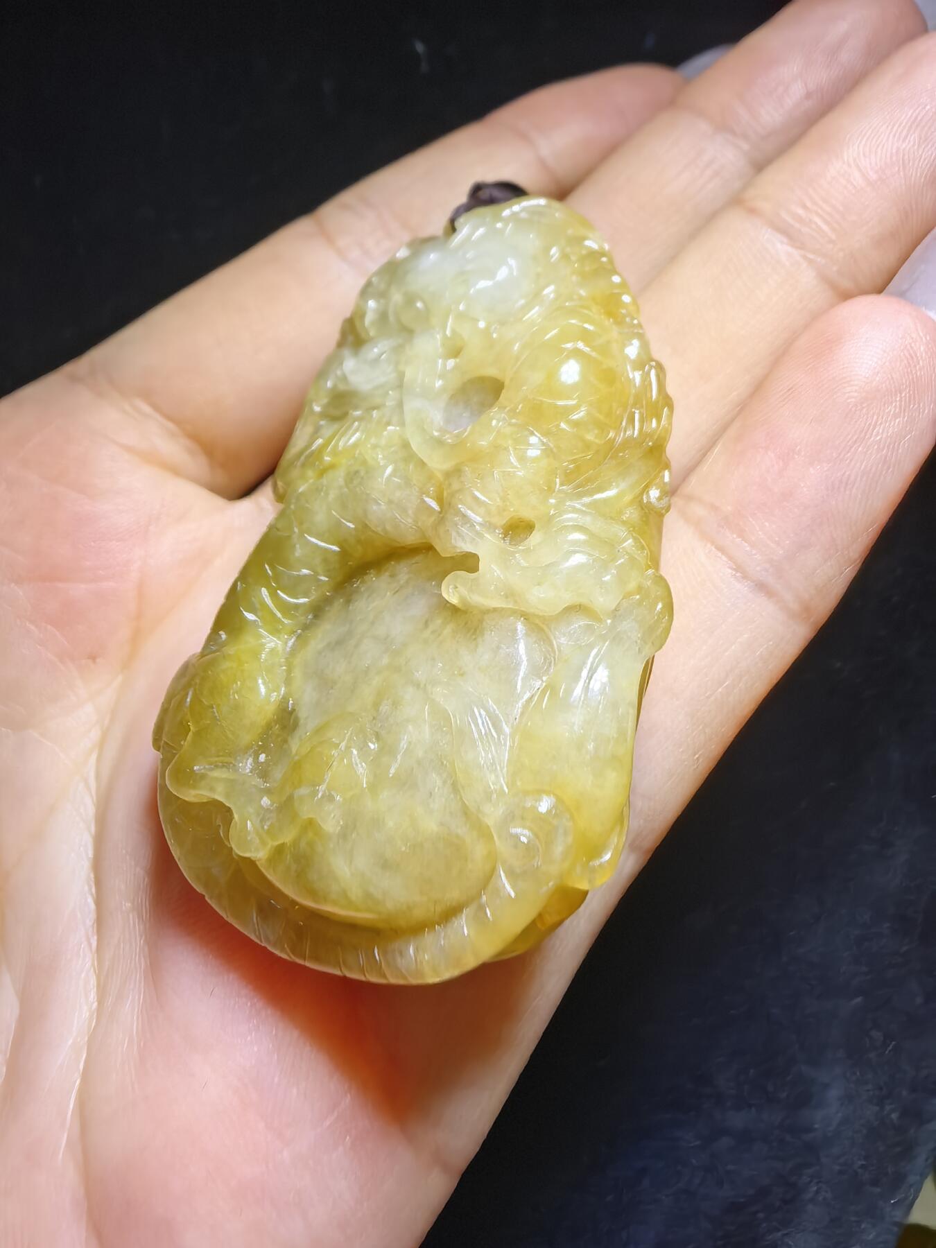 精选天然黄翡龙牌，色泽温润如蜜，通透莹亮。整料随形巧雕，龙纹苍劲灵动，盘曲间尽展威严；背面如意纹饰，线条流畅，寓意顺遂安康。黄翡为“金”，龙主祥瑞，金运与贵气相融，是随身护佑的雅器，亦是收藏赏玩的佳选。5.2cm*3.5cm*1.3cm