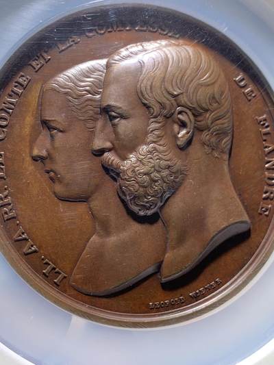 《竞宝斋》第484场 周日，周一，周二 3场连拍 （全场包邮）20级店铺 欢迎送拍 NGC MS62 1867年原铸比利时王子菲利普王室主题婚礼纪念超大铜章，顶级章牌师 Wienner制造雕刻，该章是由比利时王室委托Wiener工坊铸造，仅用于馈赠王室成员，外交使节及贵族，是重要王室纪念章牌。双面高浮雕，正面菲利普与玛丽，背面五位丘比特天使，分别象征爱情、祝福、丰收等寓意，顶部天使手持花环加冕文章。直径75mm 加大盒+超厚盒，重181g