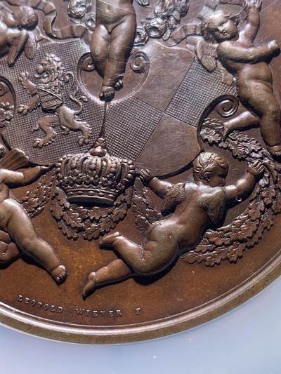 《竞宝斋》第484场 周日，周一，周二 3场连拍 （全场包邮）20级店铺 欢迎送拍 NGC MS62 1867年原铸比利时王子菲利普王室主题婚礼纪念超大铜章，顶级章牌师 Wienner制造雕刻，该章是由比利时王室委托Wiener工坊铸造，仅用于馈赠王室成员，外交使节及贵族，是重要王室纪念章牌。双面高浮雕，正面菲利普与玛丽，背面五位丘比特天使，分别象征爱情、祝福、丰收等寓意，顶部天使手持花环加冕文章。直径75mm 加大盒+超厚盒，重181g