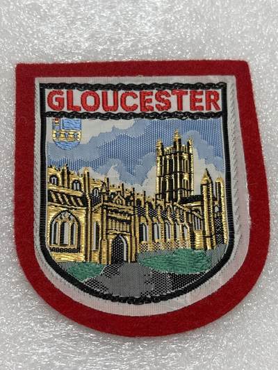 文馨钱币收藏第 302 场，国外回流老铜币，中东阿拉伯地区，拉美等国货币，30 号 1 号二连拍，长期接代拍业务，预计 4 月 4-5 号发货 格洛斯特（Gloucester）的刺绣徽章/布章  格洛斯特，英国英格兰西南部的一座城市 徽章图案描绘的是格洛斯特大教堂，这是该市最著名的地标建筑。教堂以金色刺绣呈现，背景为蓝天白云，左上方还有一个小型的盾徽图案（可能是格洛斯特市的市徽元素）。  是格洛斯特郡的郡治，位于英格兰西南部，塞文河畔。格洛斯特大教堂始建于公元678年，是一座具有悠久历史的哥特式建筑，也是《哈利·波特》系列电影的取景地之一