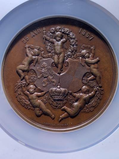 《竞宝斋》第484场 周日，周一，周二 3场连拍 （全场包邮）20级店铺 欢迎送拍 NGC MS62 1867年原铸比利时王子菲利普王室主题婚礼纪念超大铜章，顶级章牌师 Wienner制造雕刻，该章是由比利时王室委托Wiener工坊铸造，仅用于馈赠王室成员，外交使节及贵族，是重要王室纪念章牌。双面高浮雕，正面菲利普与玛丽，背面五位丘比特天使，分别象征爱情、祝福、丰收等寓意，顶部天使手持花环加冕文章。直径75mm 加大盒+超厚盒，重181g