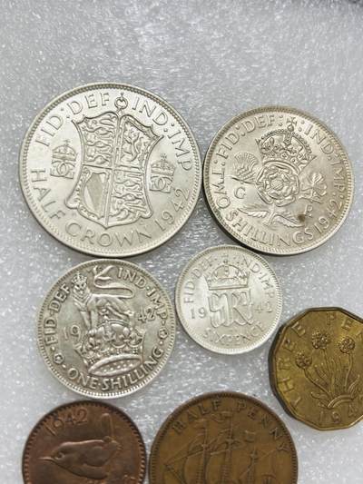 文馨钱币收藏第 302 场，国外回流老铜币，中东阿拉伯地区，拉美等国货币，30 号 1 号二连拍，长期接代拍业务，预计 4 月 4-5 号发货 英国 1942 年乔治六世 1 法新---半克朗大银币一组 7 枚，包含 4 枚银币，共 33.87 克银，均 500 银，其中 6 便士 2 先令，半克朗目测 UNC 品，总体都是极美品，喜欢的出价