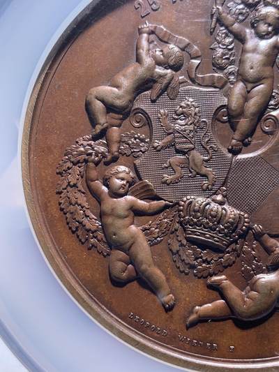 《竞宝斋》第484场 周日，周一，周二 3场连拍 （全场包邮）20级店铺 欢迎送拍 NGC MS62 1867年原铸比利时王子菲利普王室主题婚礼纪念超大铜章，顶级章牌师 Wienner制造雕刻，该章是由比利时王室委托Wiener工坊铸造，仅用于馈赠王室成员，外交使节及贵族，是重要王室纪念章牌。双面高浮雕，正面菲利普与玛丽，背面五位丘比特天使，分别象征爱情、祝福、丰收等寓意，顶部天使手持花环加冕文章。直径75mm 加大盒+超厚盒，重181g