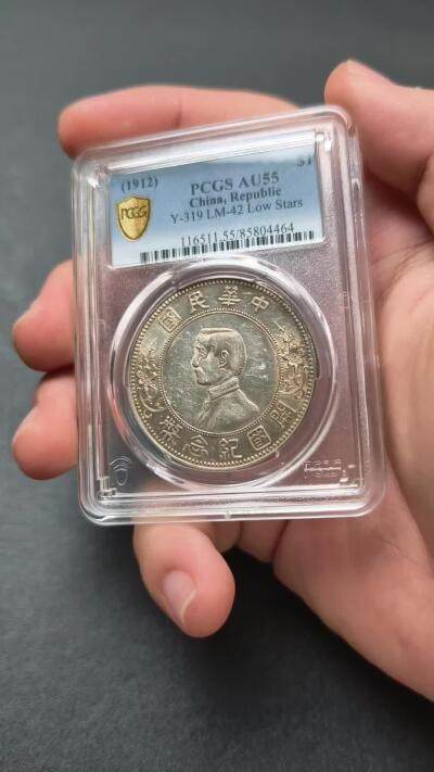 PCGS-AU55 孙中山像开国纪念壹圆下五星版 极为稀少的大名誉品 通体黄油光淡彩包浆 压印深峻精美 币面充盈温润原光，光气十足 该品种麦稀奇首拍，贴脸入手机会不容错过