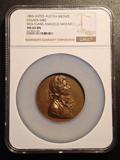 【德藏】世界币章拍卖第185期 - NGC MS64 BN 1896年奥地利沃尔夫冈·阿马德乌斯·莫扎特纪念铜章，目录Hauser 2483，正面采用莫扎特经典侧面肖像，面部神情儒雅，卷发、领结与服饰层次细腻，充分体现十九世纪奥地利奖章艺术风格；背面数位小天使飞舞于云间，手持乐器、花环与桂冠，象征音乐、荣耀与不朽，构图轻盈优美